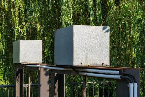 Two concrete blocks on a metal structure under a willow tree Stock Photos