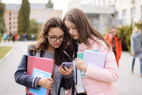 Two confused students reading bad news on the phone Stock Photos