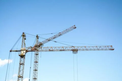 Two Construction crane. Blue construction crane against a clear sky. Stock Photos