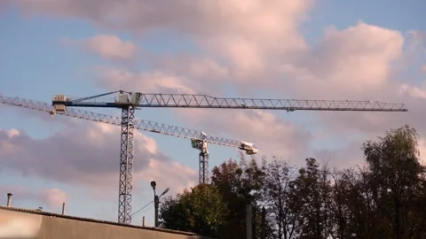 Two construction cranes against the background of fast moving clouds. Time-lapse Stock-Footage 144224483