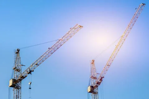 Two construction cranes against the blue sky. The concept of building a place Stockfoto's