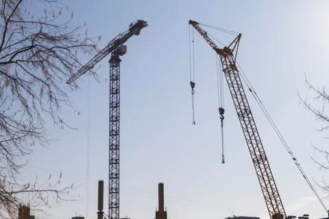 Two construction cranes on the blue sky background. Stock Photos