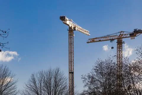 Two construction cranes in the sun with blue sky Stock Photos