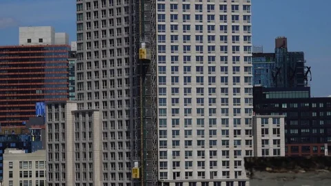 Two construction elevators moving up and down the side of a building Stock Footage 114083835