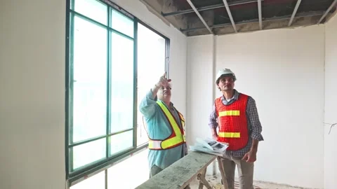 Two construction engineers assess ceiling framework at a building site. Stock Footage 312617431