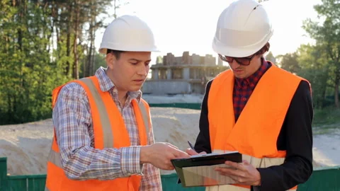 Two construction engineers discuss the construction of a residential house on th Stock Footage 85719177