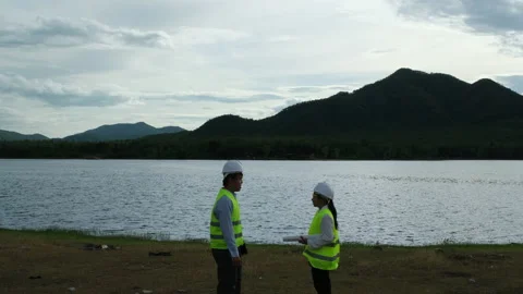 Two construction engineers discuss construction projects at the reservoir. Stock Footage 198112022