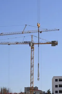 Two construction tower cranes working at a building site Stock Photos