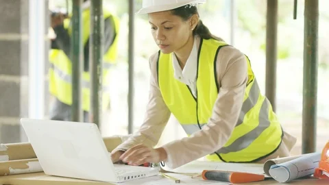 Two construction using a laptop while studying blueprint Stock Footage 108169302