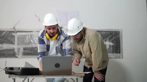Two construction workers are looking on a laptop and discussing the project Video stock 236176278