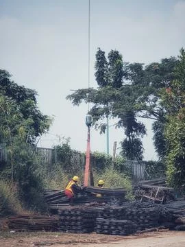 Two construction workers are mobilizing pieces of structural steel. This proc Stock Photos