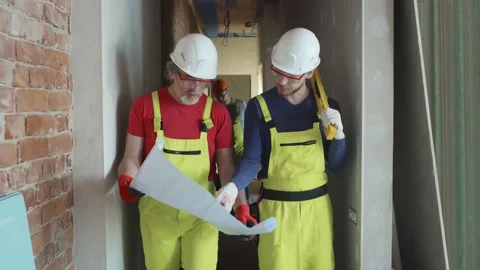 Two construction workers with blueprint at construction site 動画素材 133635839