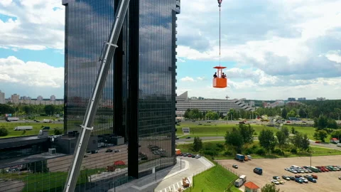 Two construction workers in the building cradle of a mobile crane. Aerial view. Vídeo Stock 138078218