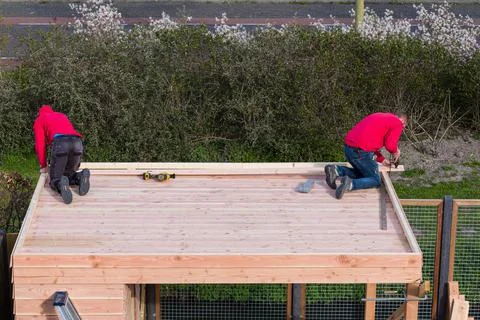 Two construction workers building a shed and veranda Stock Photos