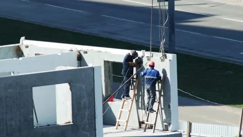 Two Construction Workers Collaborate On Upper Floor. One Worker Welds As Stock-Footage 325698700