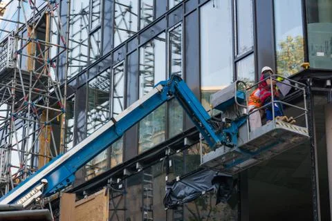 Two Construction Workers on Crane Building Exterior Stock Photos