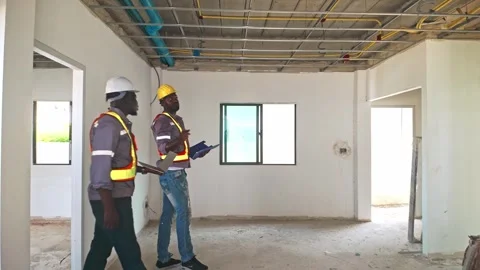 Two construction workers inspect ceiling wiring inside a house under renovate Stock Footage 327695372