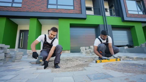 Two construction workers installing and laying pavement stones on terrace, road Stock-Footage 293634536
