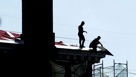 Two construction workers installing metal roofing. Russia - 22 September 2026 Stock Footage 341833423