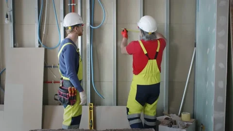 Two construction workers insulate walls on renovation site Stock Footage 133640628