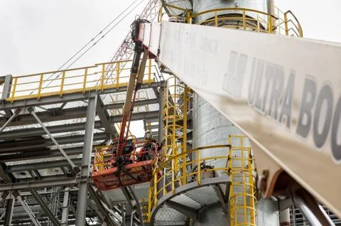 Two construction workers in lifting cage Stock Photos
