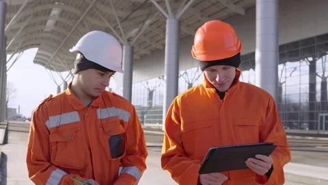 Two construction workers in orange unifo... | Stock Video | Pond5