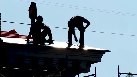 Two construction workers repairing metal roof. Russia - 22 September 2026 Stock Footage 341833362