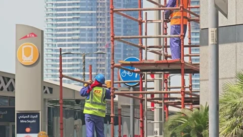 Two construction workers on scaffolding, one in a yellow vest. Stock Footage 311590815