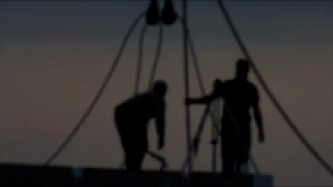 Two construction workers silhouette at job site against twilight sky with Stock Footage 323912247