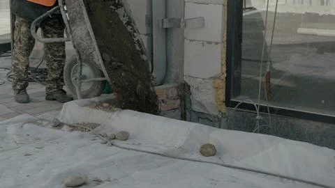Two construction workers on site discussing blueprints and progress 스톡 사진