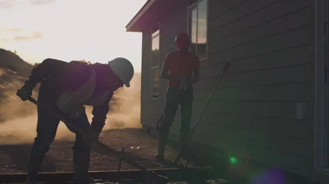 Two construction workers spreading newly poured concrete Stock Footage 55170880