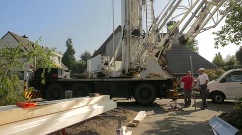 Two construction workers standing and  talking in front of a moving crane Stock Footage 41813510