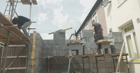 Two construction workers talking to each other one a building site Stock Footage 246380974