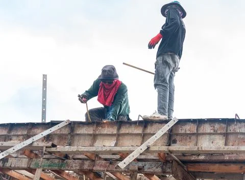 Two construction workers working on a high metal scaffolding structure unde.. 库存照片