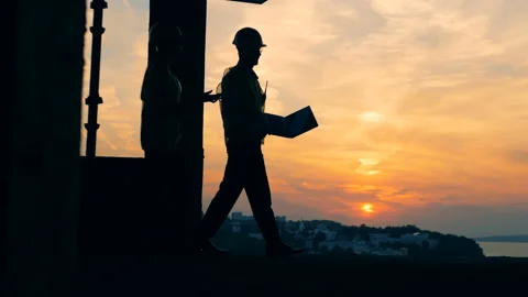 Two constructors are talking while going along the construction site. Vídeos de archivo 95685695