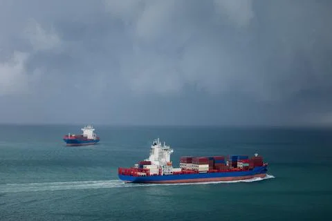 Two Container Ships Navigating Deep Blue Ocean Waters Under Stormy Sky Wide.. Foto stock