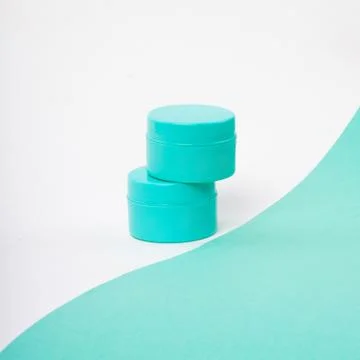 Two containers of mint color on a mint white background. Stock Photos