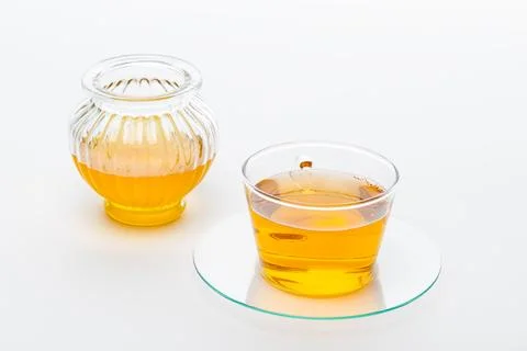 Two containers with tea placed on a white background during the daytime in .. Stock Photos