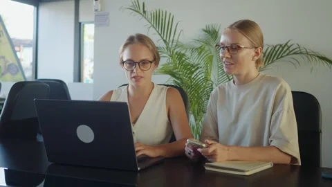 Two Content Creator are working together in modern office, using laptop and Stock Footage 312120594
