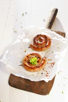 Two cooked sausages in a swirl shape Stock Photos