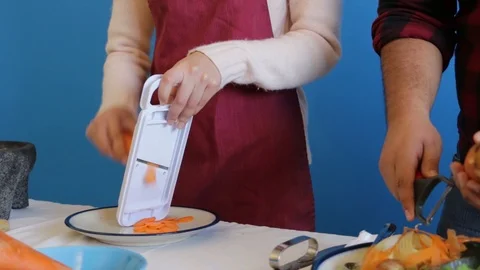 Two cooking students learning to use mandolin slicer Stock-Footage 124664825