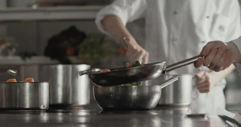 Two cooks preparing food in the kitchen Stock Footage 254764234
