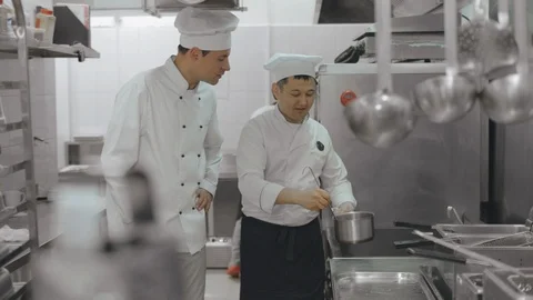 Two cooks preparing soup in modern restaurant kitchen Stock Footage 125050255