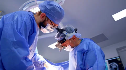 Two cooperating surgeons work at surgery Stock Footage 307940805