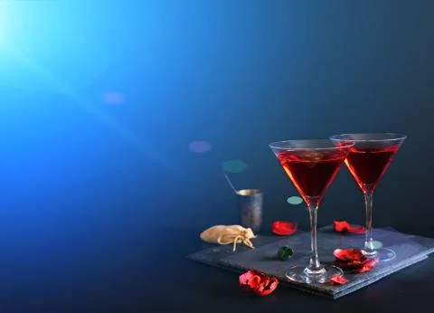 Two cosmopolitan cocktails in a triangular glass. Dark luxury background. In Stock Photos