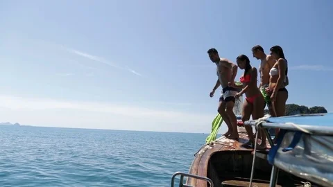 Two Couple Jumping In Water From Long Tail Boat Holding Hands, Young Man And Stock Footage