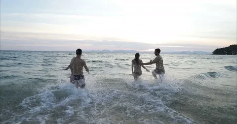 Two Couple Running In Sea Water Making Splash Holding Hands, Group Of Friends On Stock Footage