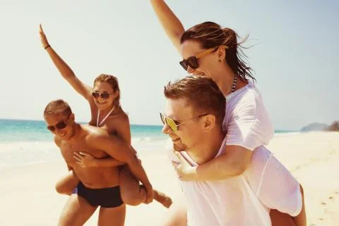 Two couples friends fun beach run Stock Photos