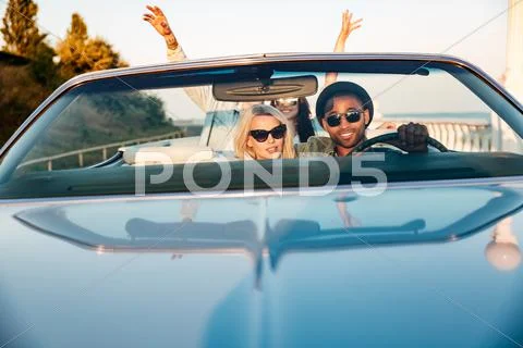Two couples with raised hands in the car Stock Photos