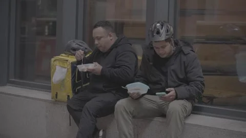 Two couriers eating on the sidewalk in Madrid, Spain Stock-Footage 345030272
